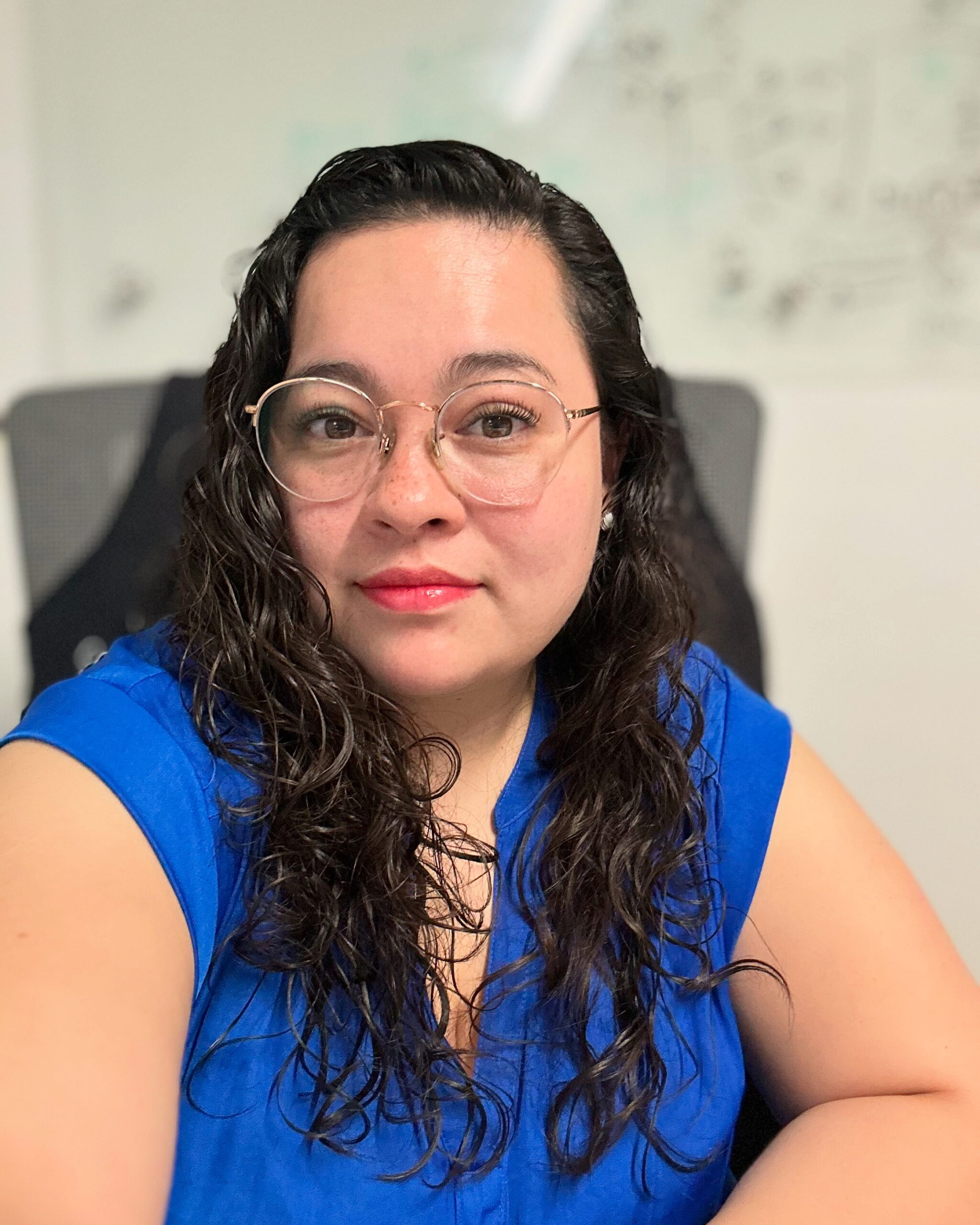 Mujer en un escritorio con blusa color azul